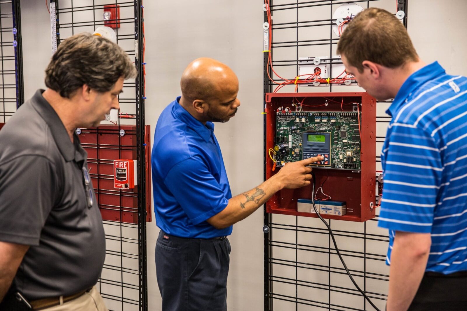 Engineer working alongside a technician in front of an fire protection control panel or training session in progress